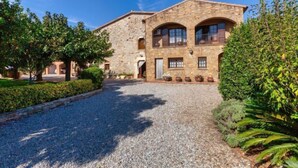 A stone building with a gravel driveway, surrounded by greenery. - Can Magi by Interhome (Pals)