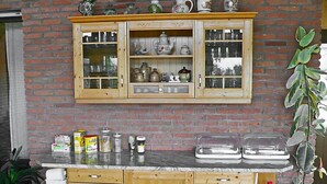 Una cocina con armarios de madera, encimera de mármol y pared de ladrillo.