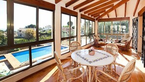A spacious room with a large window overlooking a pool and a view of the surrounding landscape. - Els Pins by Interhome (Calpe/Calp)