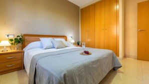 A neatly arranged bedroom with a bed, bedside tables, a lamp, and a wardrobe. - Vacation home Alex by Interhome (Deltebre)