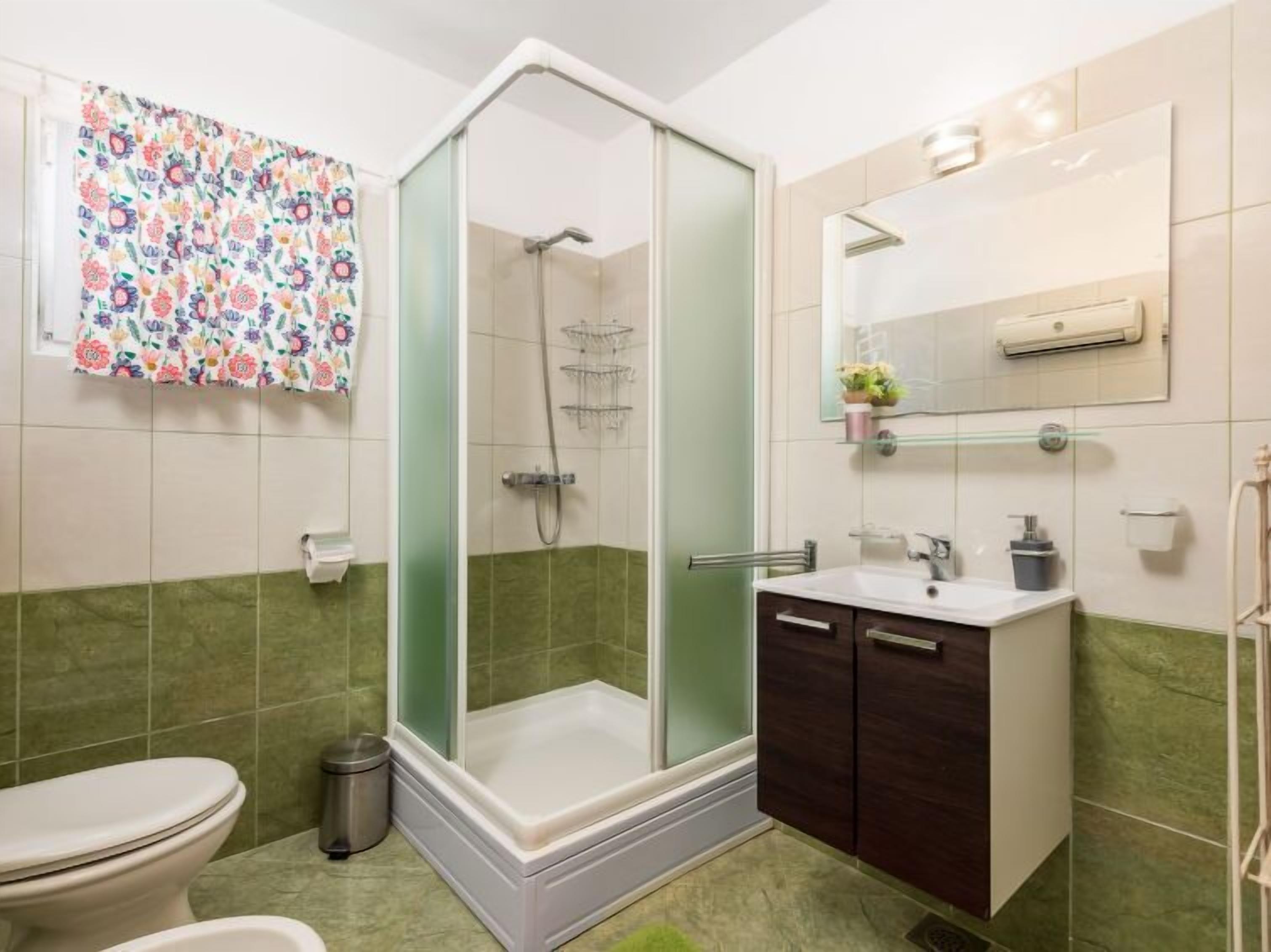 A bathroom with a shower, toilet, and sink.