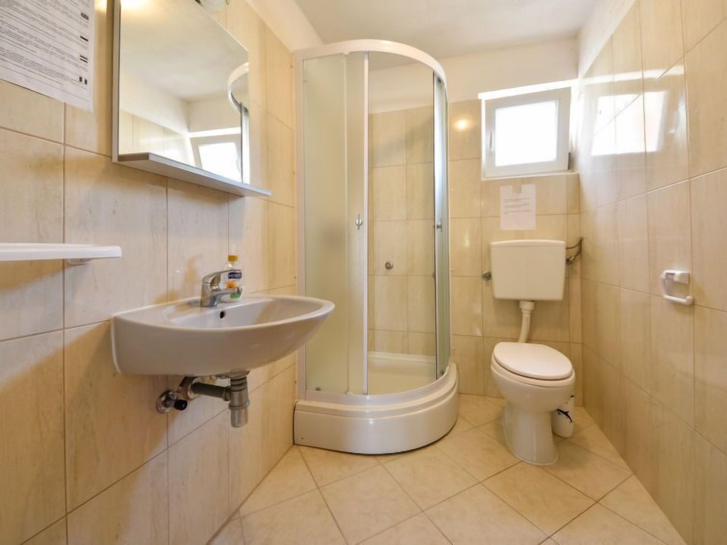 Une salle de bain moderne avec une douche à parois de verre, un lavabo et des toilettes.