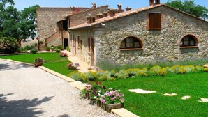 A stone building with a sloped roof, arched windows, and a small porch. - San Lorenzo by Interhome (Gambassi Terme)