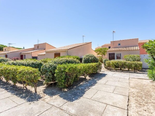 Un barrio residencial con varias casas, senderos pavimentados y setos bien cuidados.