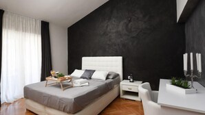 A modern bedroom with a large bed, bedside tables, a desk, and a potted plant. - Vacation home Jure by Interhome (Zadar)