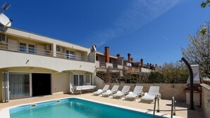 A pool area with lounge chairs and a clear blue sky. - Vacation home Jure by Interhome (Zadar)