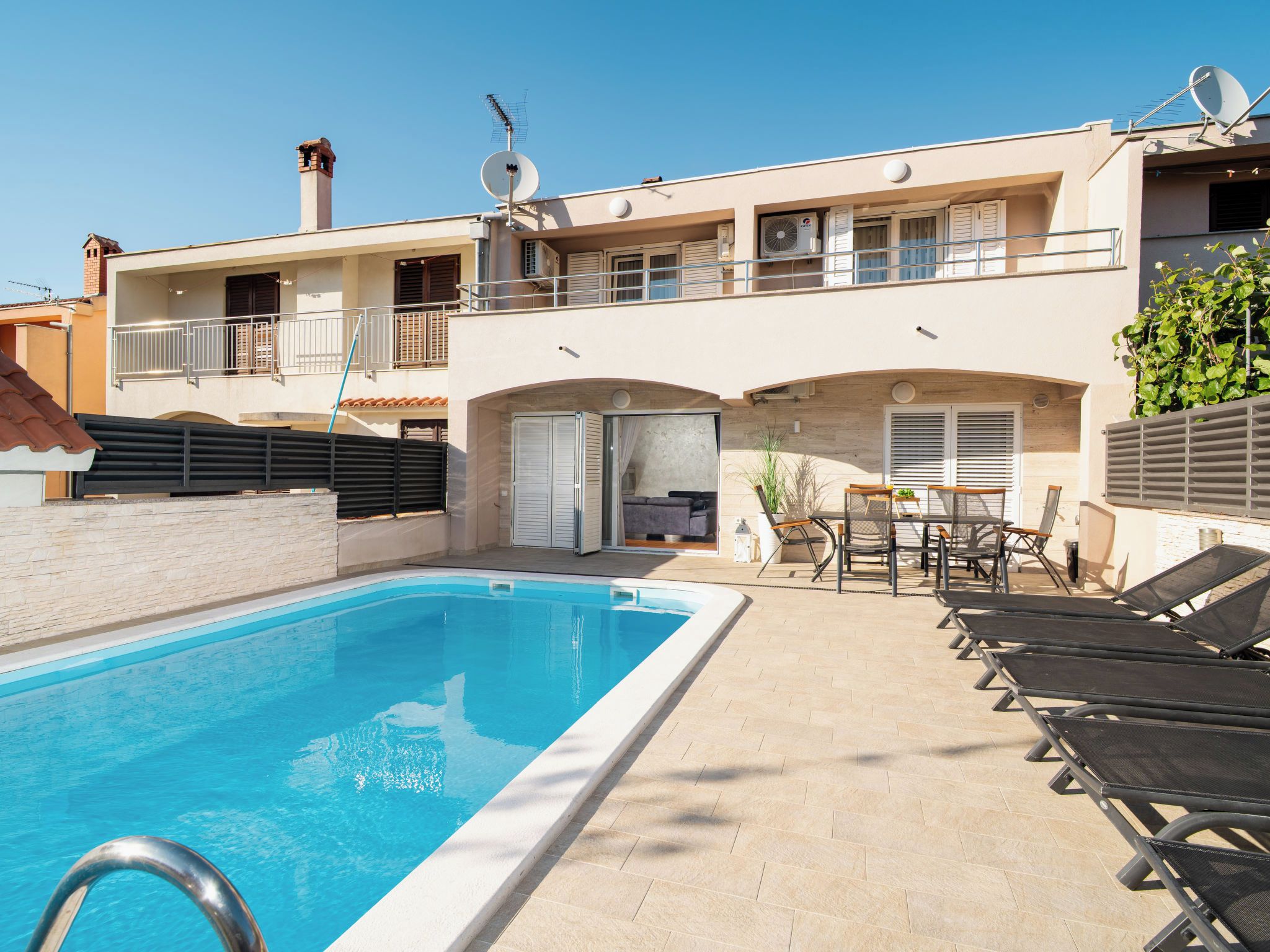 Il s’agit d’une propriété résidentielle dotée d’une piscine, d’un espace extérieur aménagé et d’un bâtiment à deux étages avec des balcons.