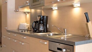 A modern kitchen with a built-in microwave, coffee maker, and dishwasher. - Bella Monte by Interhome (Pettneu am Arlberg)