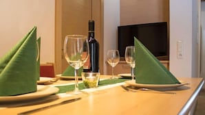 A hotel room dining table set with a bottle of wine, two glasses, and a small bowl of olives. - Bella Monte by Interhome (Pettneu am Arlberg)