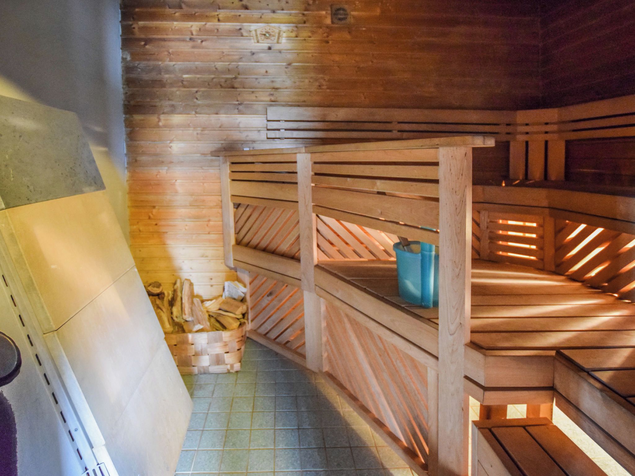 Un sauna avec des bancs en bois et un sol carrelé.