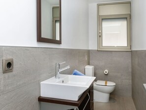 A bathroom with a white sink, a mirror, and a toilet. - Palmbeach by Interhome (Lloret de Mar)