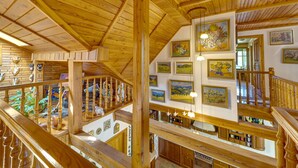 A multi-level wooden interior with a staircase, wooden beams, and artwork on the walls. - Borówna by Interhome (Borowna)