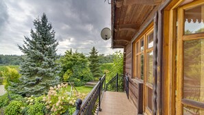 A wooden building with a balcony, satellite dish, and a view of trees and greenery. - Borówna by Interhome (Borowna)