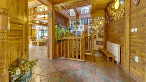 A wooden interior with a tiled floor, a wooden staircase, and a wall decorated with pictures. - Borówna by Interhome (Borowna)