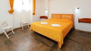Ein Schlafzimmer mit einem hölzernen Bett, weißen Wänden und einem Holzboden.