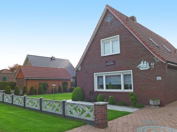 A brick house with a gabled roof, a small window, and a sign that reads "Haus zucker". - Büscher by Interhome (Grossheide)