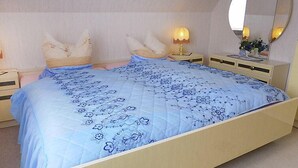 Et soveværelse med en seng, to sengeborde, et natbord, en lampe og et spejl.