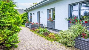 A modern house with a paved driveway, flower boxes, and a brick pathway. - Głęboczek 21 by Interhome (Gleboczek)