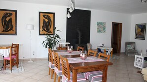 A dining area with a wooden table, chairs, and a black stove.