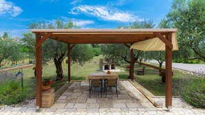 A covered outdoor patio with stone flooring, a table, and chairs. - Apartment SaNi by Interhome (Pula)