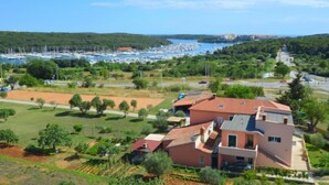 A coastal town with a marina, green fields, and residential buildings. - Apartment SaNi by Interhome (Pula)