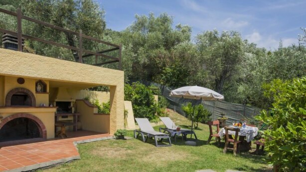 Un espace extérieur aménagé avec un chemin en pierre, des sièges et un barbecue.
