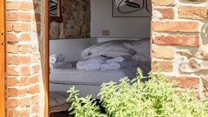 Une chambre avec un lit, des serviettes et un mur en briques.