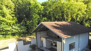 Moderni talo, jossa on patio, ulkotila istuimineen ja uima-allas.