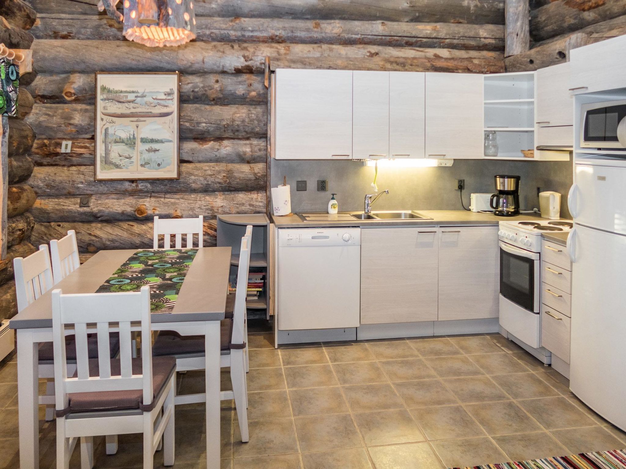 A rustic kitchen with wooden walls, a dining table with chairs, and modern appliances.