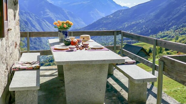 A stone table with benches on a balcony overlooking a mountainous landscape. - Baita Ficc by Interhome (Ponto Valentino)