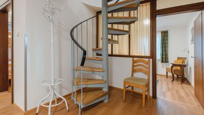 Un intérieur moderne avec un escalier en colimaçon, un plancher en bois et une chaise blanche.