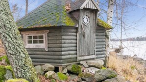 Un rustico chalet con tetto spiovente, un camino e una porta con un maniglione decorativo.