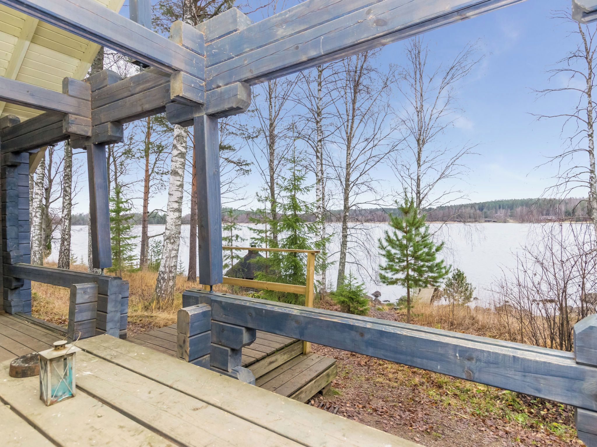 A wooden deck with a view of a lake and trees.