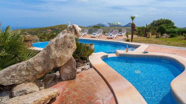 A swimming pool with a stone sculpture, lounge chairs, and a view of the sea. - Cala Torta Na Moli by Interhome (Cala Torta)
