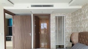 Ein Schlafzimmer mit Bett, Kleiderschrank, eingebautem Heizkörper und einem Fenster mit Jalousien.
