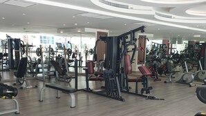 Ein modernes Fitnessstudio mit verschiedenen Trainingsgeräten, darunter Laufbänder und Kraftgeräte.