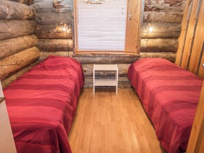 A log cabin room with two beds, a small table, and a window with blinds. - Rukajoiku 1 by Interhome (Kuusamo)