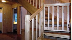 A wooden staircase with a railing, leading to an upper floor.