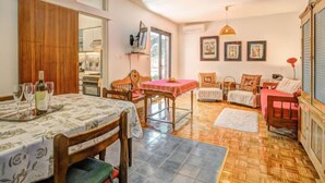 Un comedor con una mesa dispuesta para cuatro, una silla de madera y una silla con respaldo en forma de corazón.