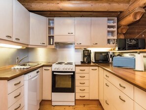 Een kleine keuken met een fornuis, oven, magnetron en vaatwasser.