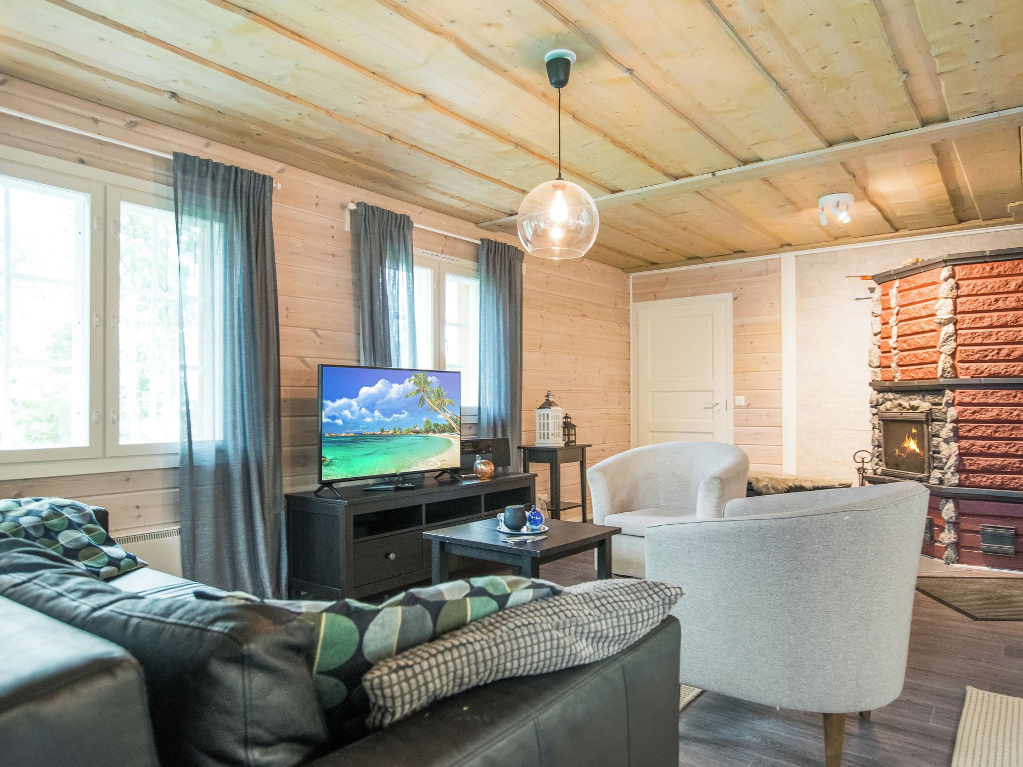 Un salon chaleureux avec un téléviseur, une cheminée et un coin salon confortable.