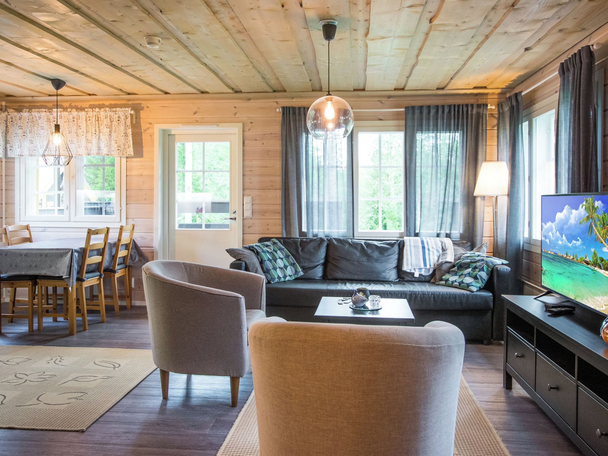 A cozy living room with a sofa, chairs, a coffee table, and a television.