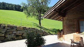 A wooden cabin with a stone wall and a potted plant in the foreground. - Katharina by Interhome (Aschau im Zillertal)