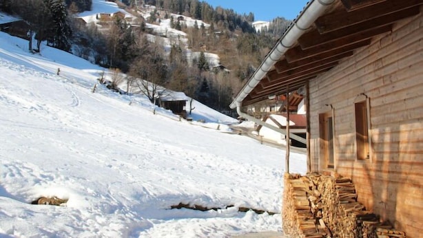A wooden cabin with a snow-covered landscape, a clear sky, and a distant mountain range. - Katharina by Interhome (Aschau im Zillertal)
