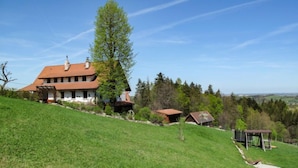 A large house with a sloped roof, surrounded by a grassy hill and trees. - Vacation home Lhotka by Interhome (Ostravice)