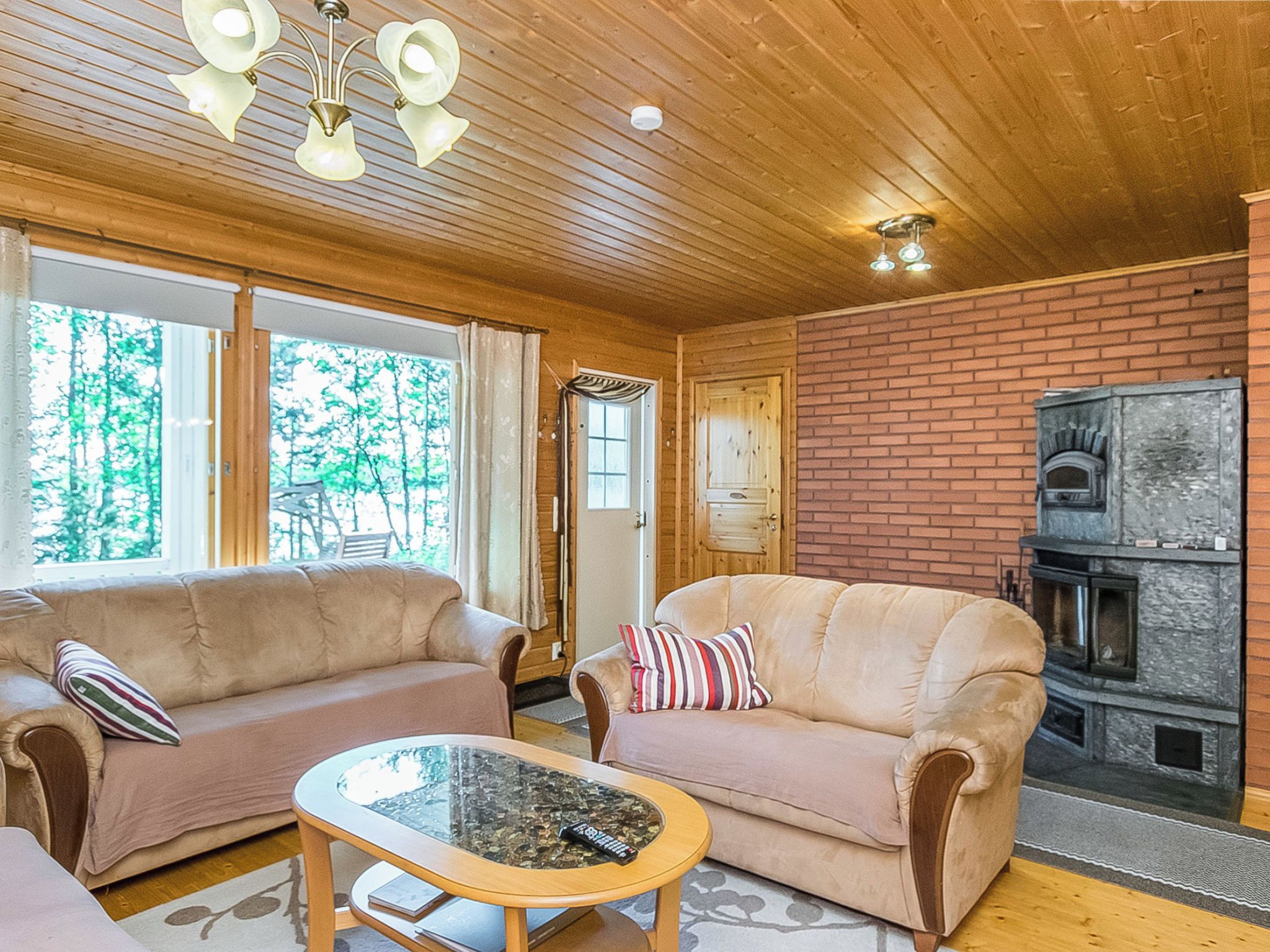 A cozy living room with two sofas, a glass coffee table, and a fireplace.