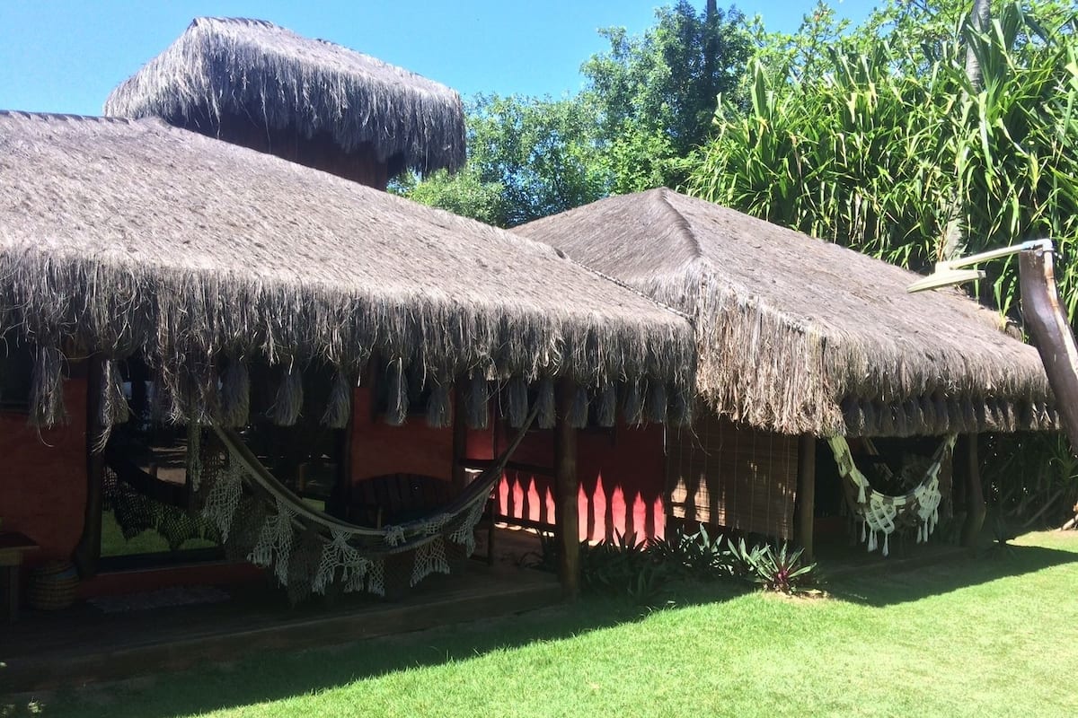 A traditional thatched-roof structure with a hammock and a small porch area.