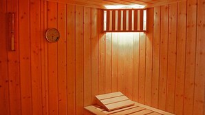 Un sauna con paredes de madera y un banco.