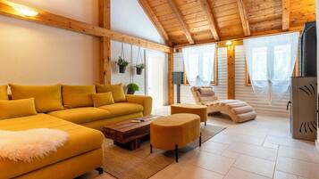 Un salon chaleureux avec un canapé jaune, une table basse en bois et une cheminée.