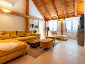 A cozy living room with a yellow sofa, a wooden coffee table, and a fireplace.